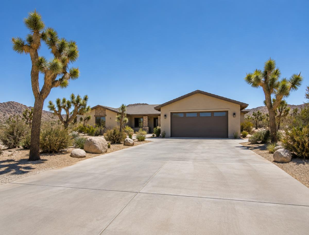 Wide new concrete driveway leading to a desert home